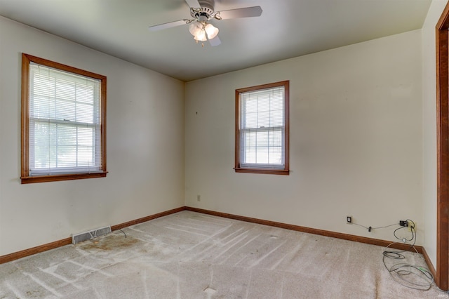 empty room with baseboards, light carpet, and visible vents