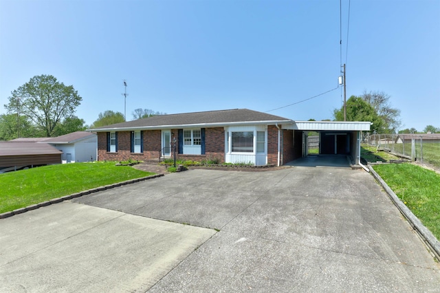 ranch-style home featuring driveway, a carport, brick siding, fence, and a front lawn