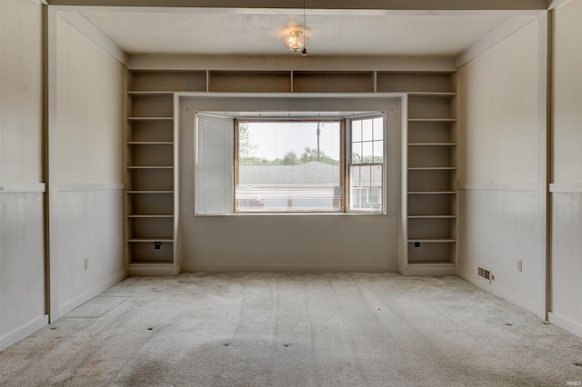interior space with visible vents and a wainscoted wall