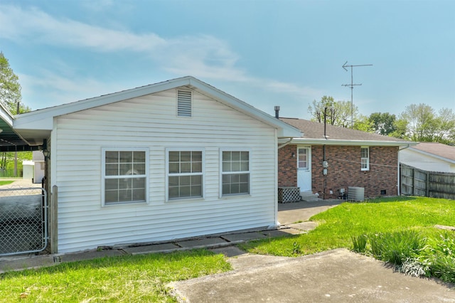 back of property with fence, central air condition unit, brick siding, entry steps, and a lawn