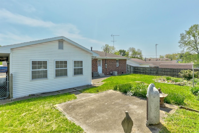 back of property with fence, a patio, a yard, and brick siding