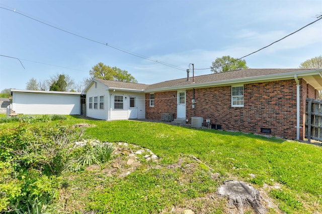 back of house featuring a lawn and brick siding