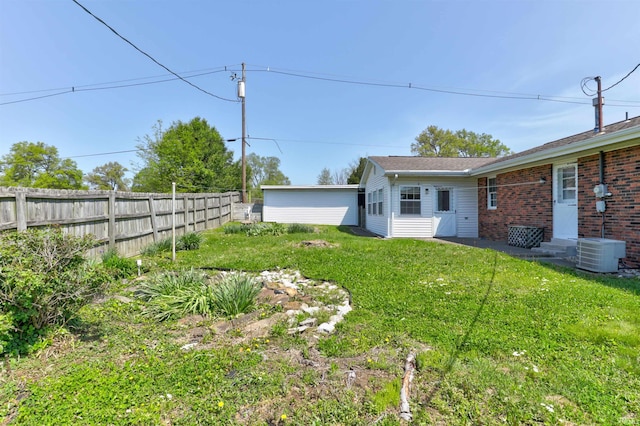 view of yard with central air condition unit, fence, and entry steps