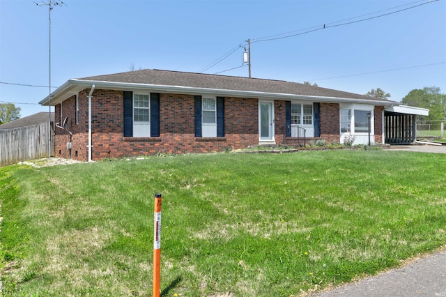 ranch-style house featuring fence, a front yard, and brick siding