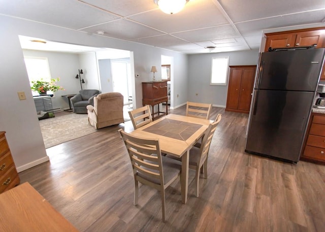 dining room with dark wood-style flooring and baseboards