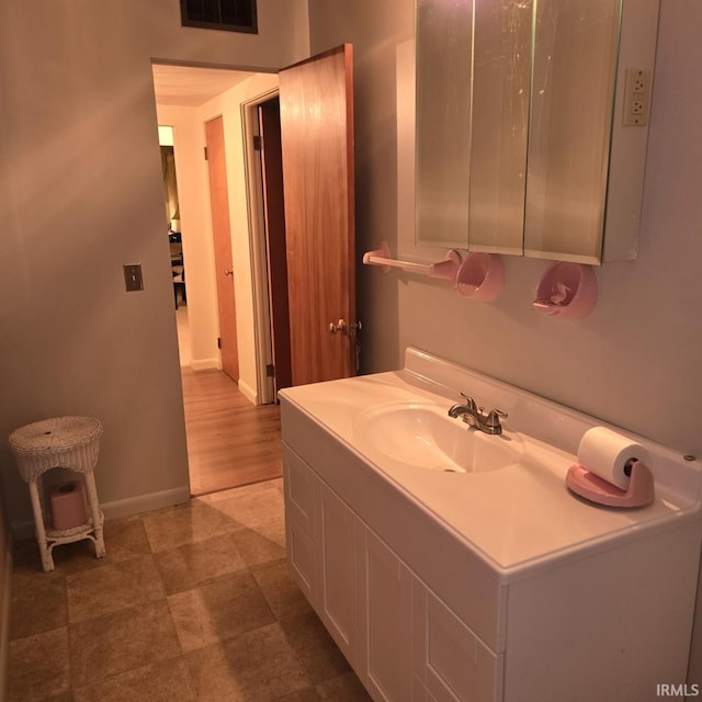 bathroom featuring baseboards, visible vents, and vanity