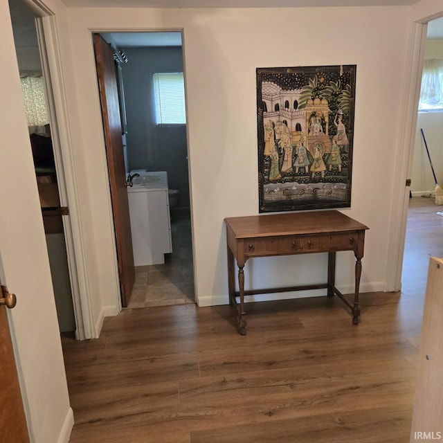 corridor with baseboards and wood finished floors