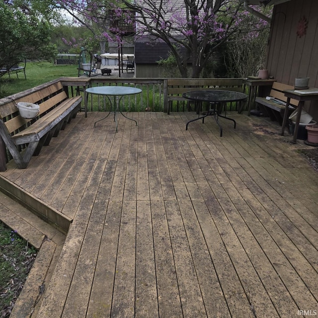 wooden terrace with a lawn and a trampoline