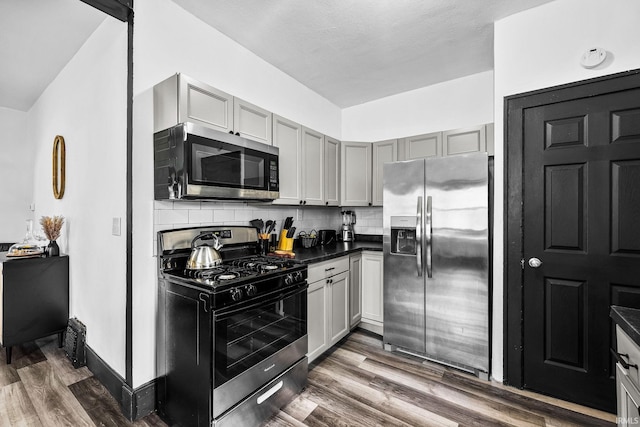 1314 Miner St, South Bend, IN 46617 - kitchen featuring dark countertops, backsplash, stainless steel appliances, and dark wood-style floors