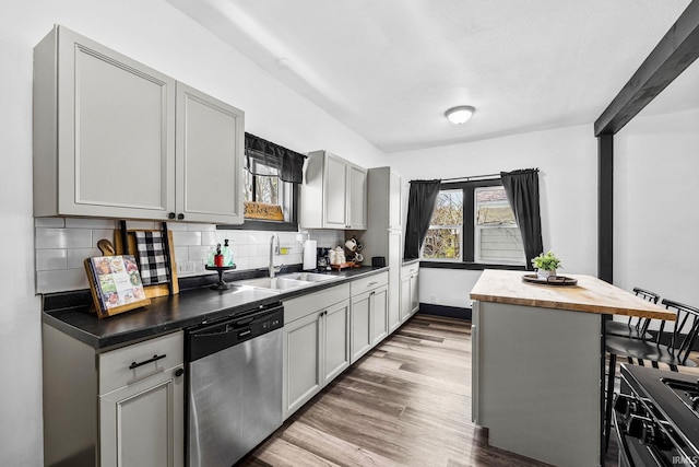 1314 Miner St, South Bend, IN 46617 - kitchen with decorative backsplash, light wood-style floors, a sink, dishwasher, and gas stove