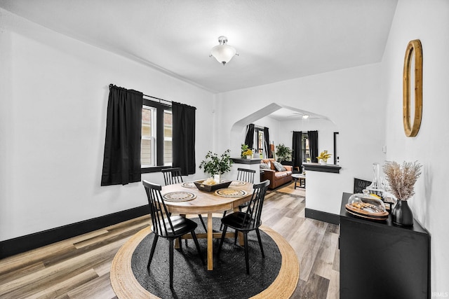 1314 Miner St, South Bend, IN 46617 - dining area with arched walkways, baseboards, a wealth of natural light, and light wood-style flooring