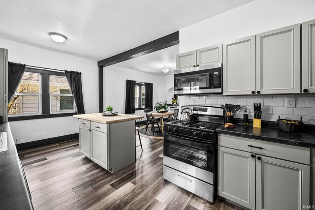 1314 Miner St, South Bend, IN 46617 - kitchen featuring decorative backsplash, wooden counters, dark wood-type flooring, gray cabinetry, and stainless steel appliances
