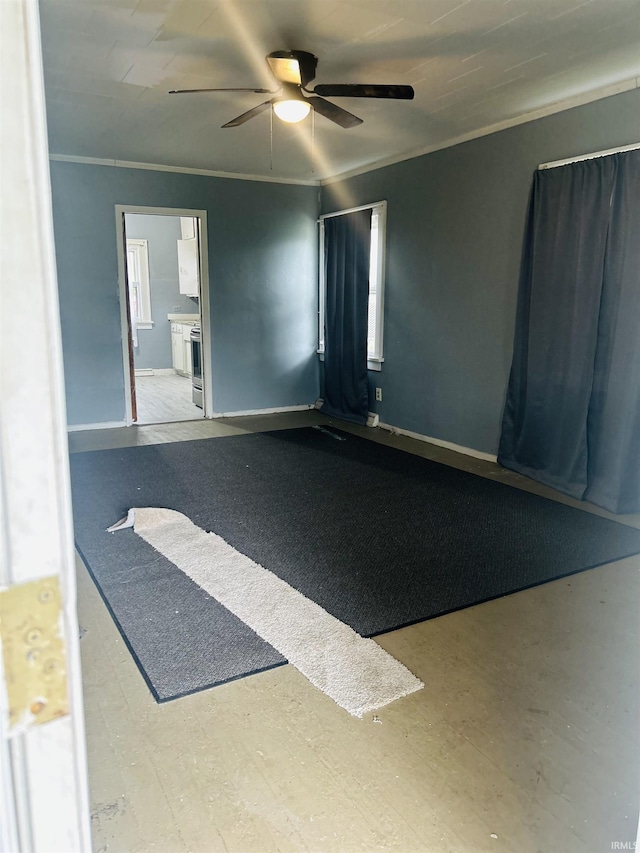 empty room with a ceiling fan, baseboards, and ornamental molding