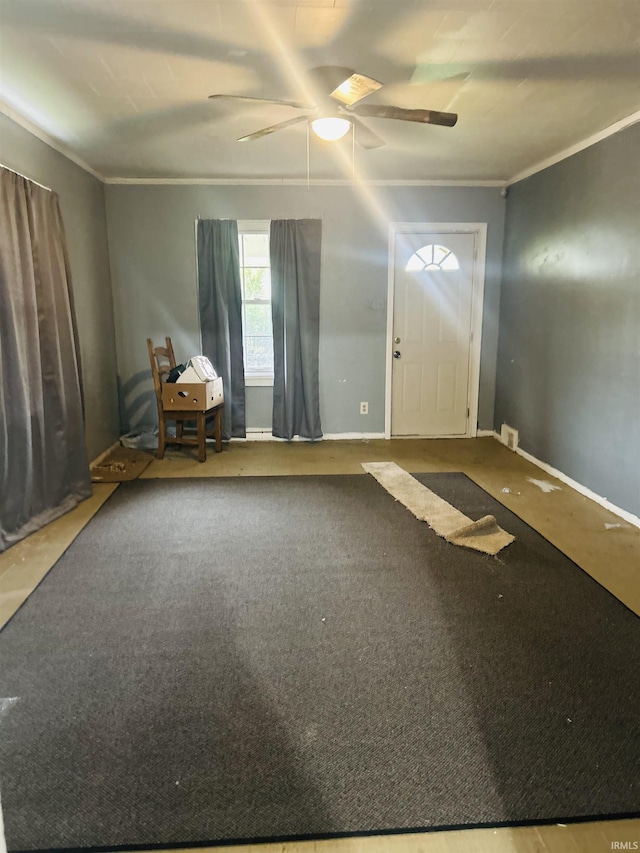 entryway with baseboards, ornamental molding, and ceiling fan
