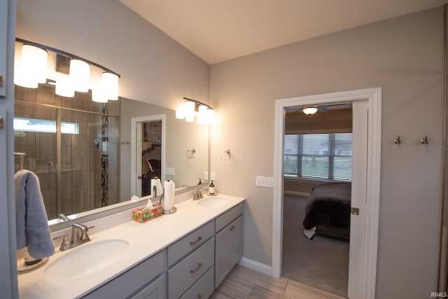ensuite bathroom with double vanity, a sink, baseboards, and a stall shower