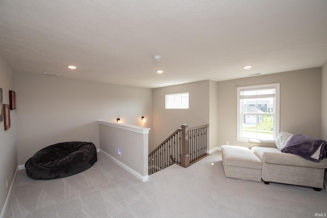 sitting room featuring carpet flooring, recessed lighting, baseboards, and an upstairs landing