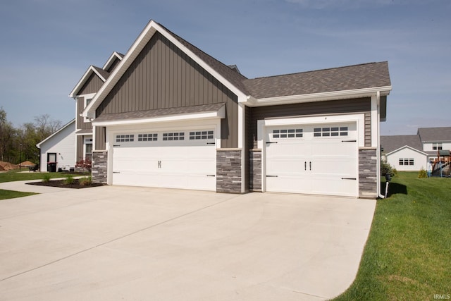 craftsman-style home with board and batten siding, an attached garage, driveway, and stone siding