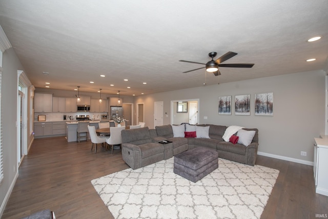 living area with baseboards, recessed lighting, dark wood-style flooring, and ceiling fan
