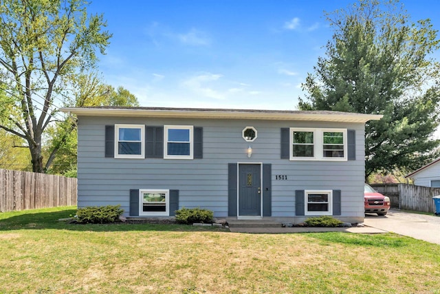 split foyer home featuring fence and a front yard