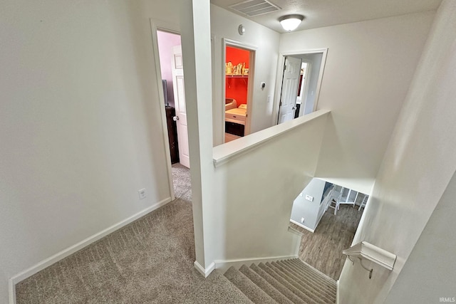 stairway with baseboards, carpet flooring, and visible vents