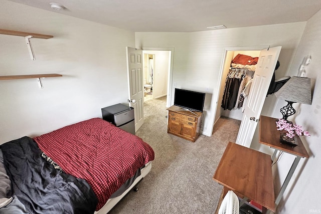 bedroom featuring a walk in closet, light carpet, a closet, and visible vents