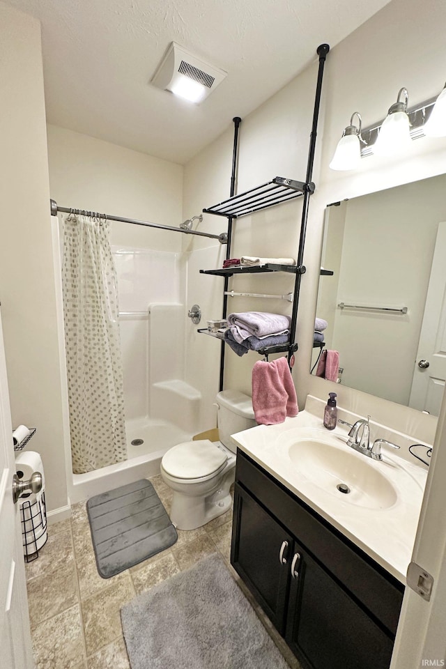 bathroom with visible vents, vanity, toilet, and a shower stall