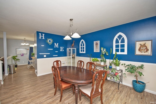 dining room featuring baseboards, a chandelier, and wood finished floors