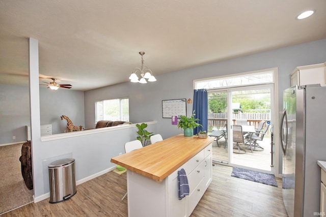 kitchen featuring light wood-style floors, freestanding refrigerator, wood counters, and white cabinetry