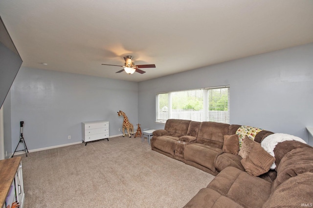 living room with baseboards, ceiling fan, and light carpet