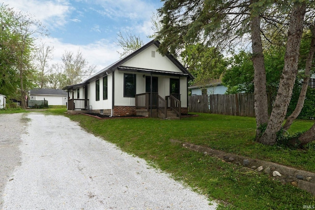view of front of property with fence, driveway, a front lawn, and crawl space