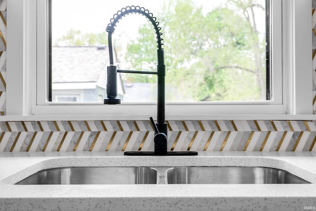 details featuring a sink and light stone countertops