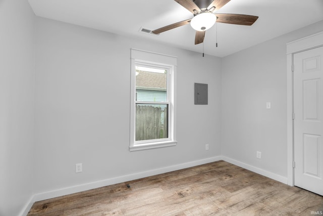 unfurnished room featuring visible vents, wood finished floors, baseboards, electric panel, and a ceiling fan