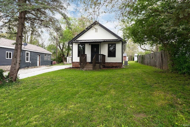 bungalow-style home featuring fence, driveway, and a front yard