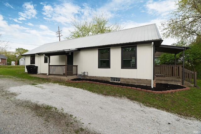 rear view of house with covered porch and metal roof