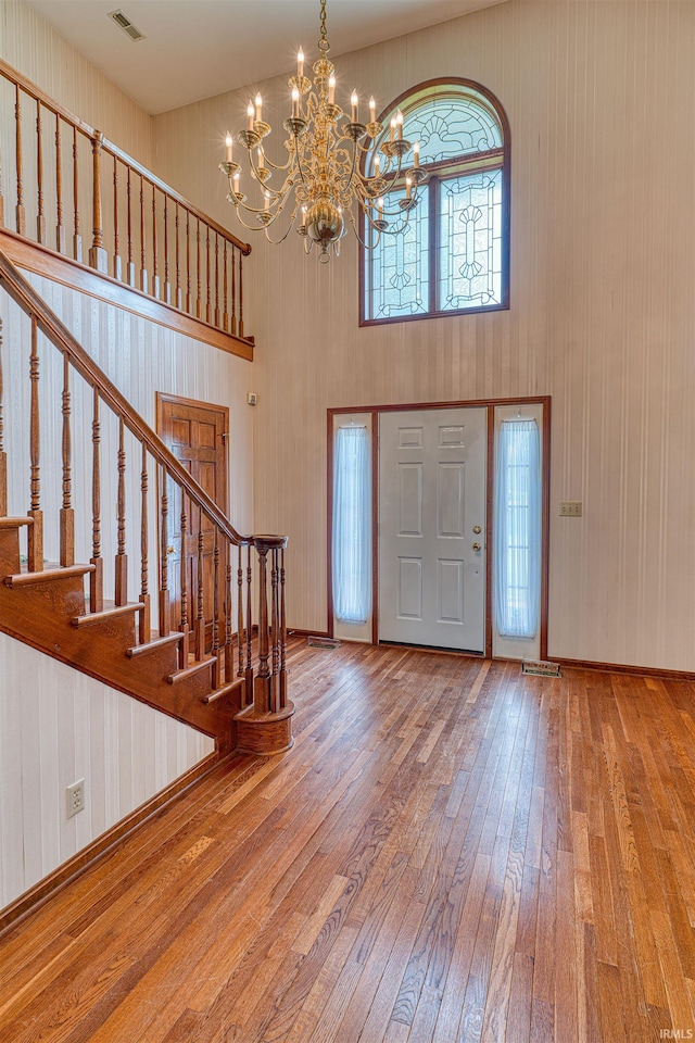 7001 Old Boonville Hwy, Evansville, IN 47715 - entryway with visible vents, a towering ceiling, wood-type flooring, an inviting chandelier, and stairs