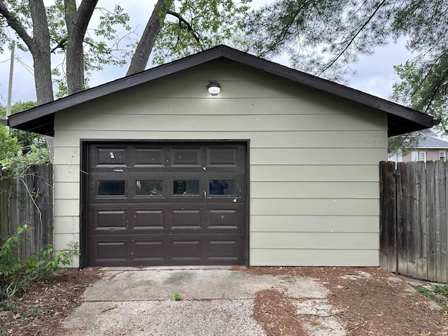 detached garage with fence and concrete driveway