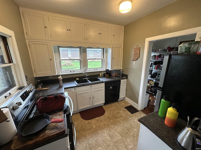 kitchen featuring a sink, appliances with stainless steel finishes, white cabinets, and dark countertops