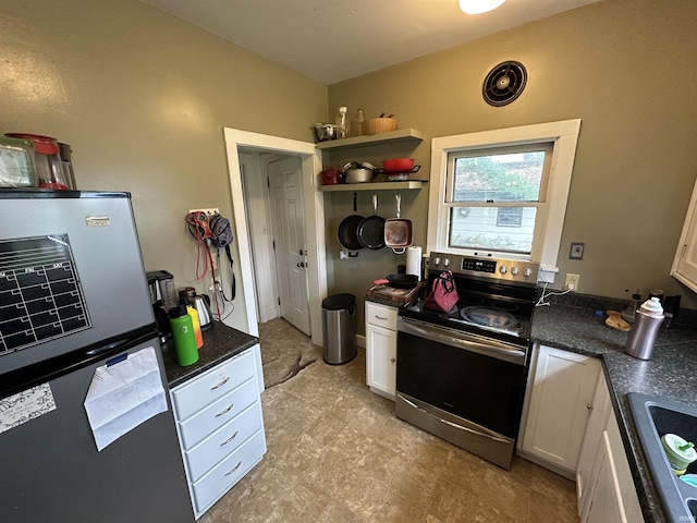 kitchen with a sink, dark countertops, stainless steel appliances, and white cabinetry