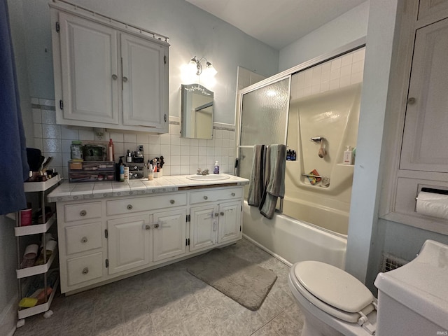 full bath featuring vanity, toilet, and shower / bath combination with glass door
