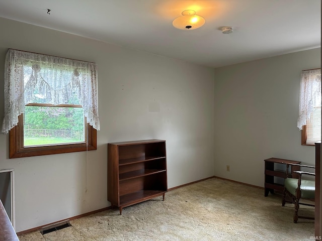 interior space with visible vents, baseboards, a wealth of natural light, and light colored carpet