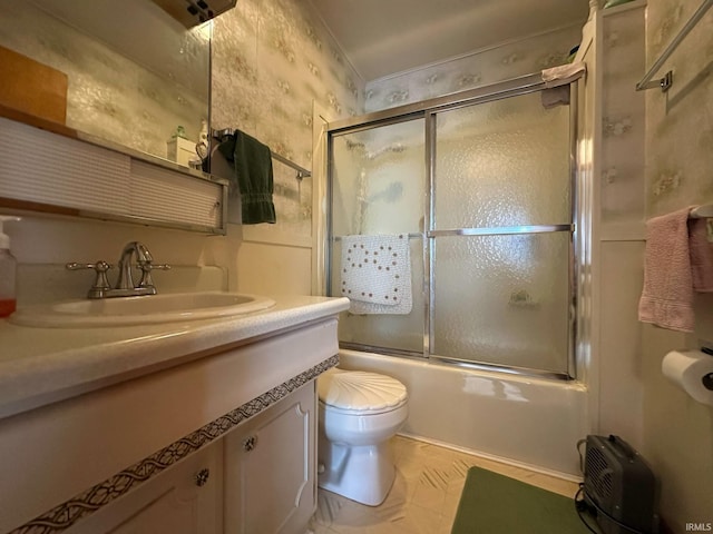 bathroom featuring vanity, bath / shower combo with glass door, toilet, and wallpapered walls
