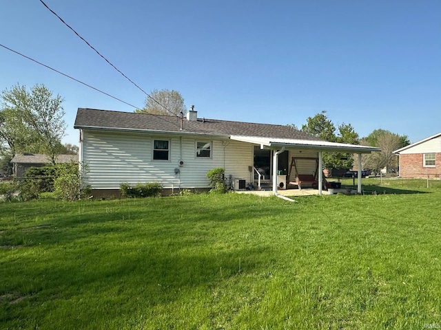 rear view of house with a chimney, a yard, and a patio area