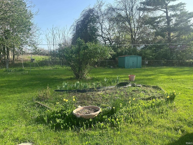 view of yard featuring fence, an outdoor structure, and a storage unit