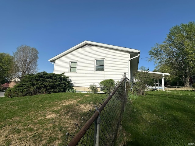 view of home's exterior with fence and a yard