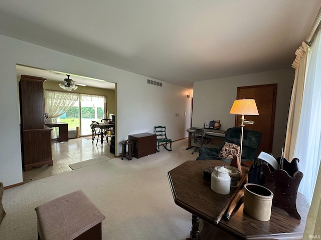 carpeted living area featuring baseboards, a ceiling fan, and visible vents