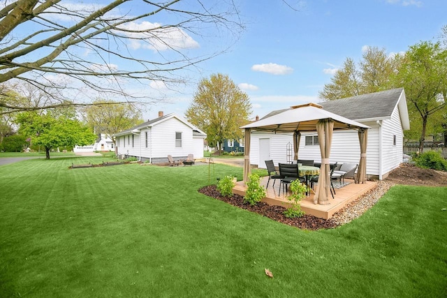 back of property featuring a lawn, a gazebo, and a shingled roof