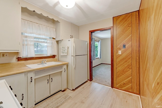 kitchen featuring light wood-style floors, freestanding refrigerator, a sink, and light countertops