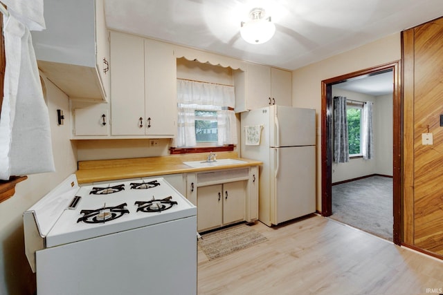 kitchen with ceiling fan, light wood-type flooring, a sink, light countertops, and white appliances