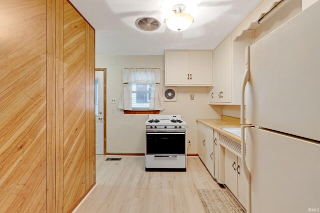 kitchen with white cabinets, white appliances, light countertops, light wood-type flooring, and visible vents
