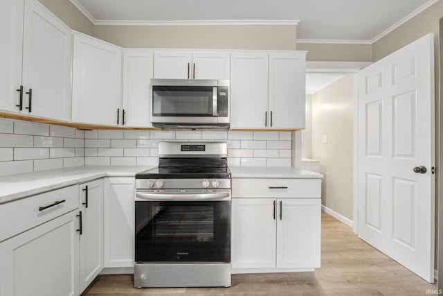 1743 Franklin Ave, Fort Wayne, IN 46808 - kitchen featuring crown molding, white cabinets, appliances with stainless steel finishes, light wood-type flooring, and backsplash
